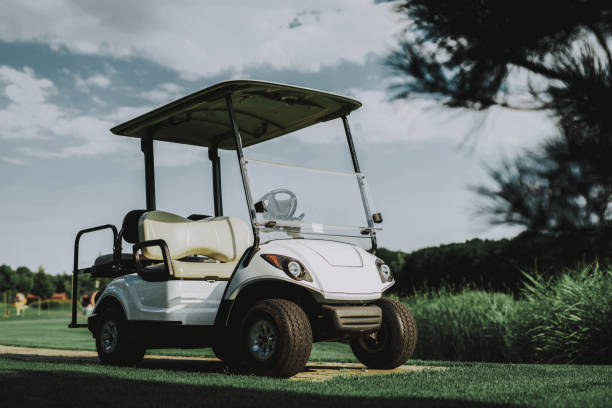 istock White Little Cart on Golf Field in Sunny Day. 1035026810
