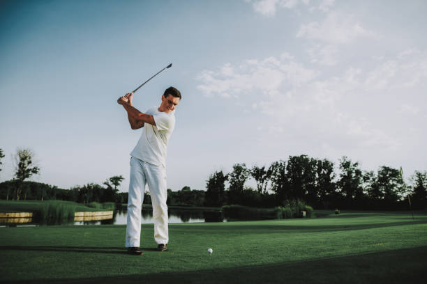istock Young Man in White Clothes Playing Golf on Field. 1035027012