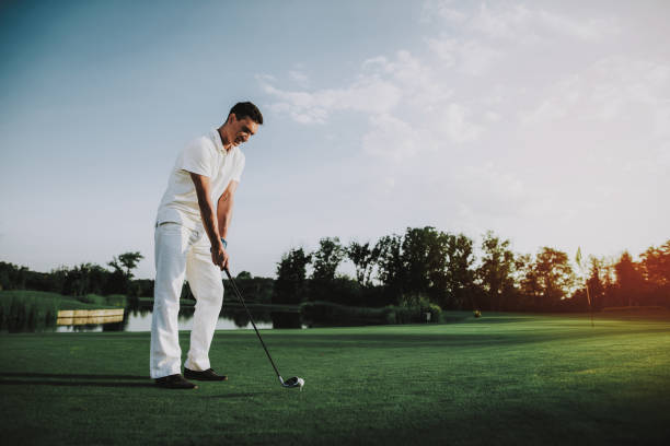 istock Young Man in White Clothes Playing Golf on Field. 1035027018