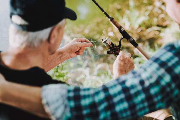 istock Old Father with Bearded Son Fishing on River. 1035027774