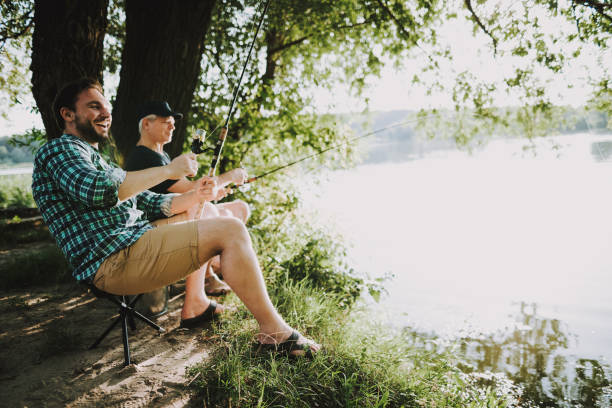 istock Young Man with Son and Father Fishing on River. 1035027862
