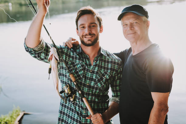 istock Old Father with Bearded Son Fishing on River. 1035027998