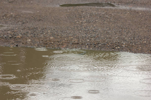 istock water puddles with raindrops and water circles 1035037902