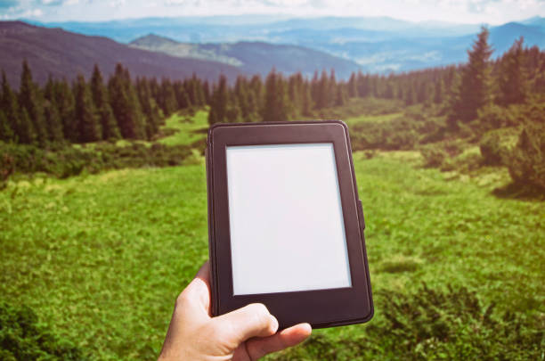istock Close-up Of Human reading e-book in nature 1035047972