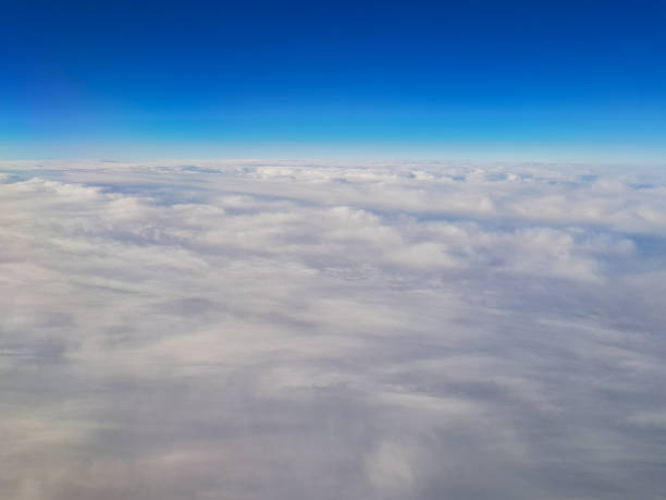 istock aerial view on clouds against clear blue sky, view from airplane 1035050038