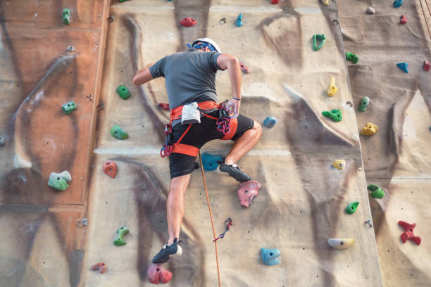 istock Young man practicing rock climbing on artificial wall indoors. 1035053020