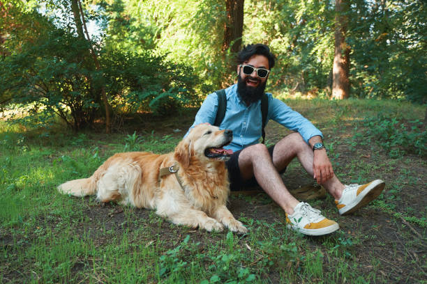 istock Man with beard and his small yellow dog playing and enjoying sun 1035054174