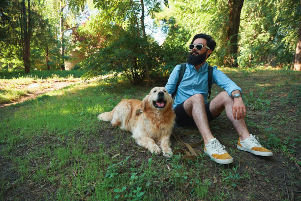istock Man with beard and his small yellow dog playing and enjoying sun 1035056676