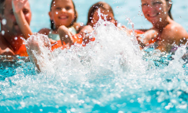 istock Family splashing in swimming pool 1035058010