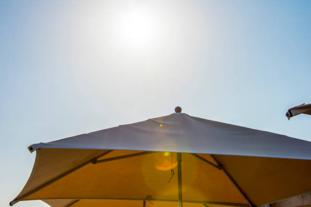 Umbrella With Bright Sun And Blue Sky