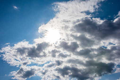 The sun shines brightly from behind a cloud creating shadows and a “ silver lining”.