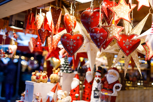 Different decoration, toy for xmas tree on christmas market, close up of cozy handmade hearts.