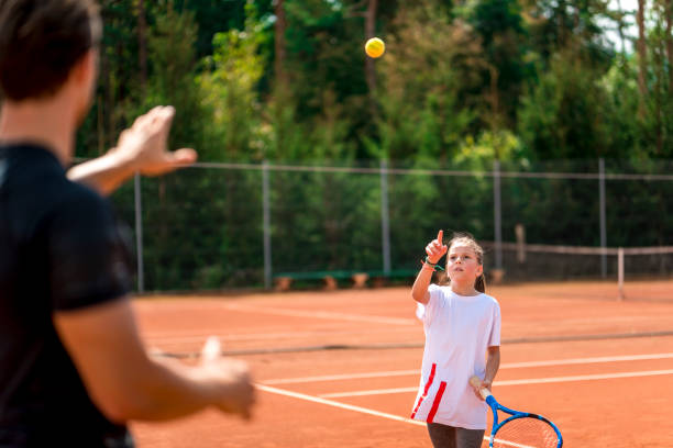 istock Young man teaching a girl playing tennis 1035072766