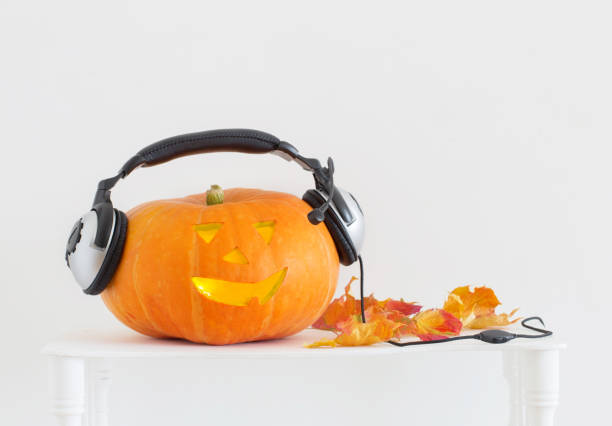 istock Halloween pumpkin with headphones on white background 1035077904