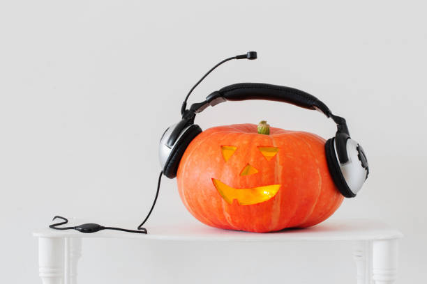istock Halloween pumpkin with headphones on white background 1035077922