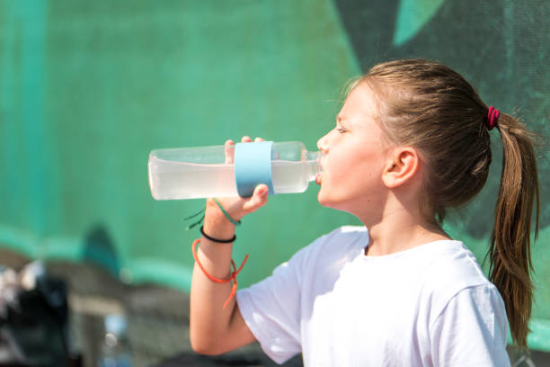 istock Little girl drinking from a bottle 1035078598