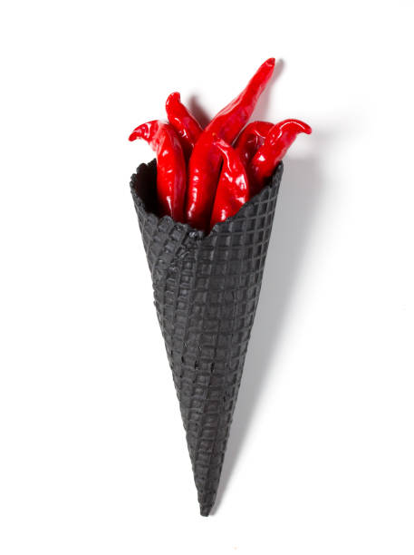istock Red chili pepper symbolizing torch with fire on White isolated background. Hot pepper in a black Ice cream cone 1035080924