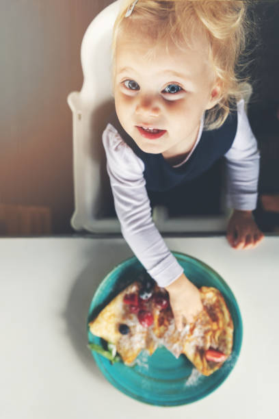 istock 2 years old child eating pancakes. top view 1035082984