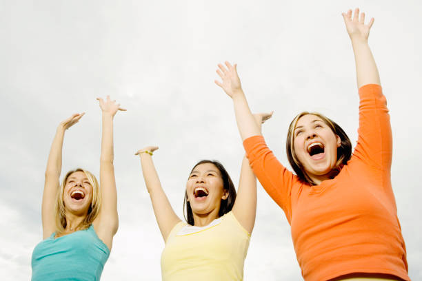 istock Three woman laughing with arms raised 1035090342