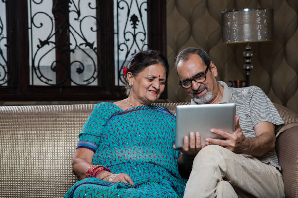 istock Mature couple laughing using a digital tablet - Stock image 1035096484