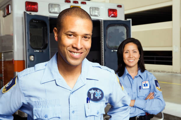 Portrait of paramedics in front of ambulance Portrait of paramedics in front of ambulance civil servant stock pictures, royalty-free photos & images