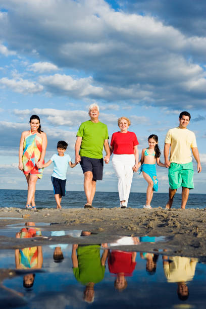 istock Hispanic family holding hands and walking on beach 1035101384