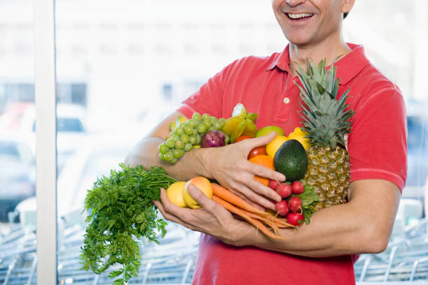istock Man holding fresh fruit and vegetables at grocery store 1035107602