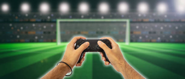 istock Male hands holding a video game controller on blur screen background 1035114038