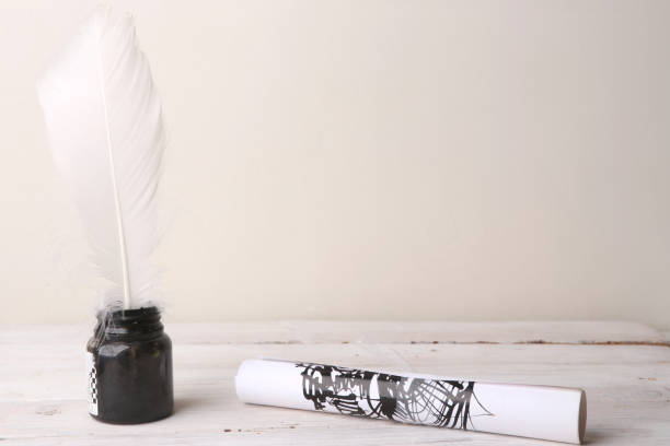 istock Ink bottle with feather and paper roller with ink drawing. 1035117842