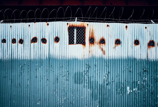 istock Corrugated metal fence with barbed wire. 1035117950