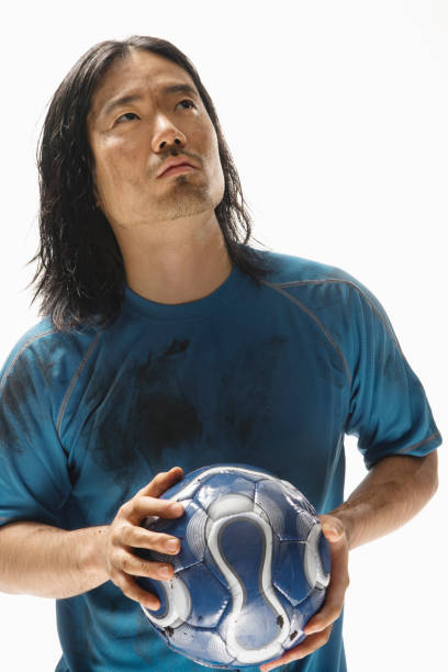 istock Asian male soccer player holding ball 1035123448