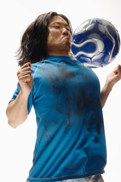 Asian male soccer player bouncing ball on chest