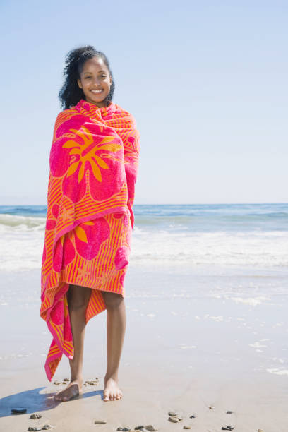 istock African woman wrapped in beach towel 1035123638