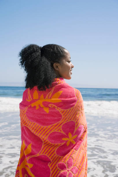 istock African woman wrapped in beach towel 1035124116