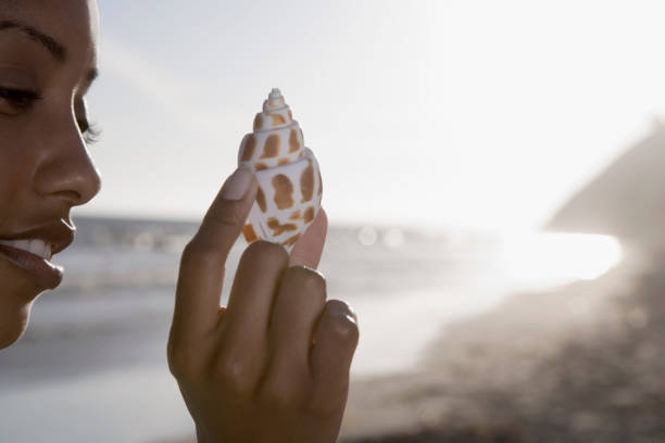 istock African woman holding seashell 1035124192