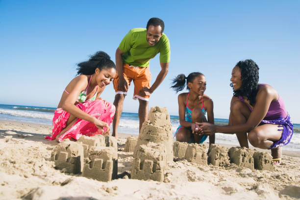 famille africaine, construction de châteaux de sable - sandcastle photos et images de collection
