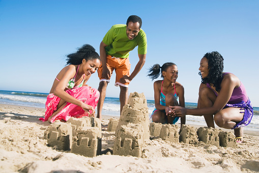 African family building sand castles