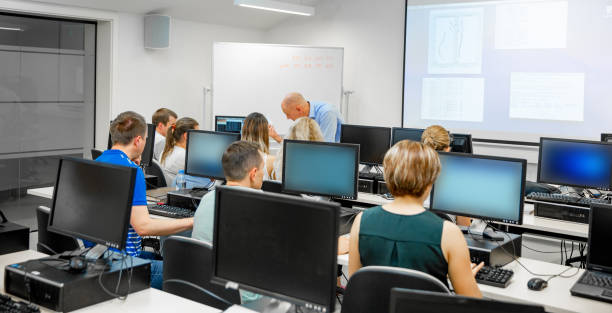 istock Students Listening to Professor in Computer Classroom 1035127264