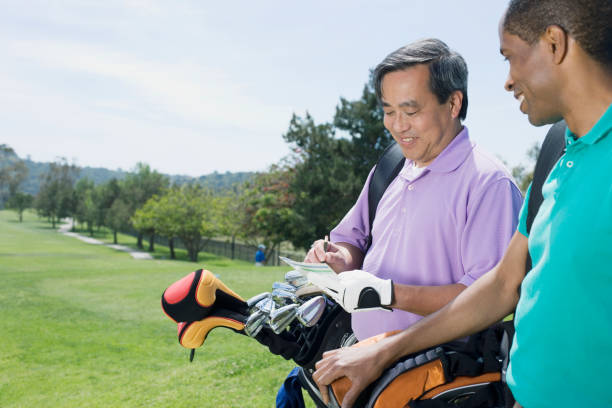 multi-ethnischen männer auf golfplatz - retirement golfer happiness relaxation stock-fotos und bilder