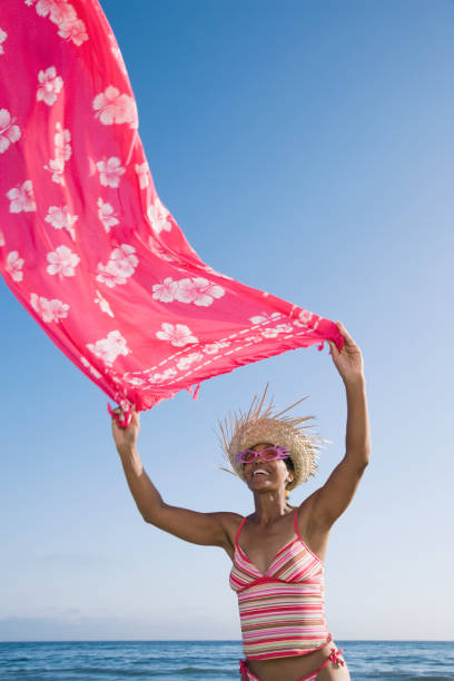 istock Mixed Race woman holding sarong in wind 1035135904
