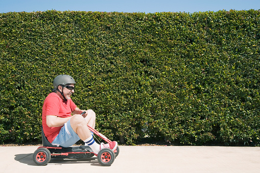 Hispanic man riding child's toy