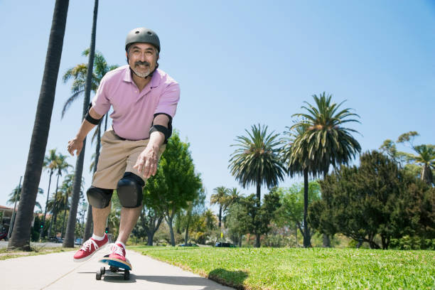 Hispanic man riding skateboard Hispanic man riding skateboard elbow pad stock pictures, royalty-free photos & images