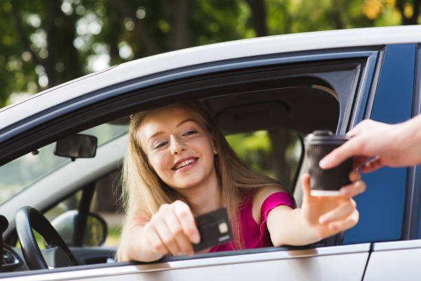 istock Girl driver pay card for coffee to go 1035146132