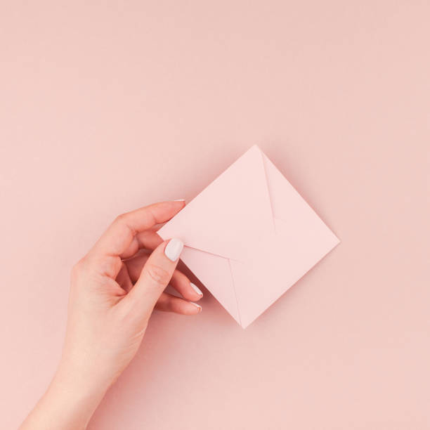 istock Woman hand holding small pink love letter 1035146556