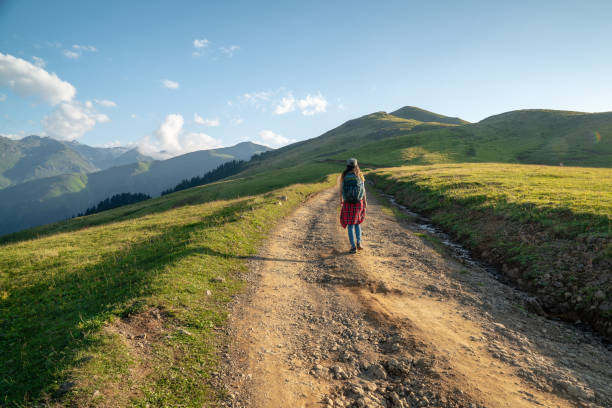 istock Young Woman with backpack walking on path.Travel Concept. 1035149412