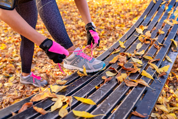 istock female runner in forest tying shoe 1035150052