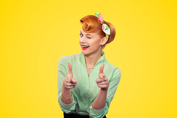 Hey you! Woman pointing index fingers gesture winking blinking eye stock photo
