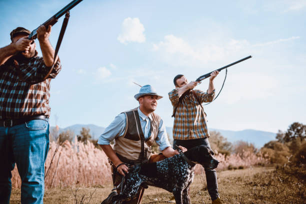 istock Hunters In Action Preparing To Shoot And Dog Pulling Chain To Help Them 1035157690