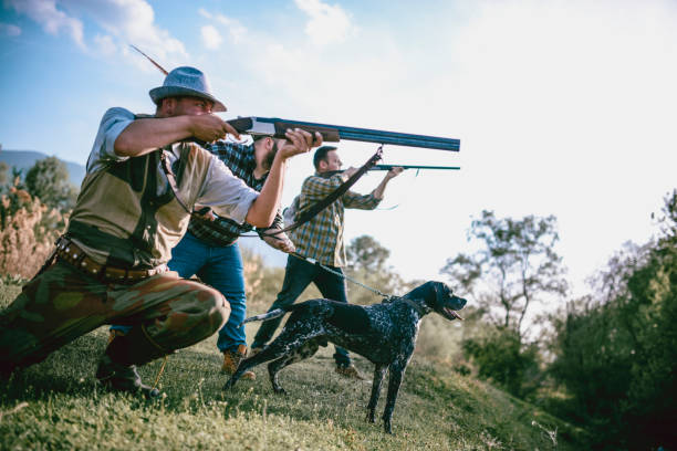 istock Hunters In Action Preparing To Shoot And Dog Pulling Chain To Help Them 1035157888