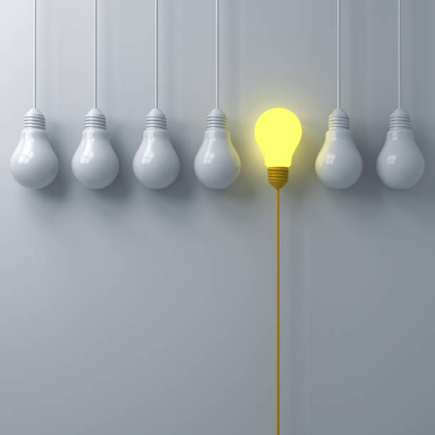 istock Think different concept One glowing light bulb standing out from the dim or unlit white lightbulbs on white wall background with shadows leadership and individuality creative idea concept 3D rendering 1035164670